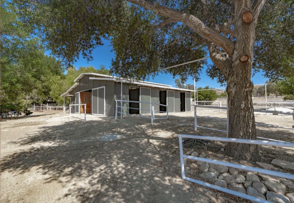 Horse stables and white fencing at Serenity Ranch